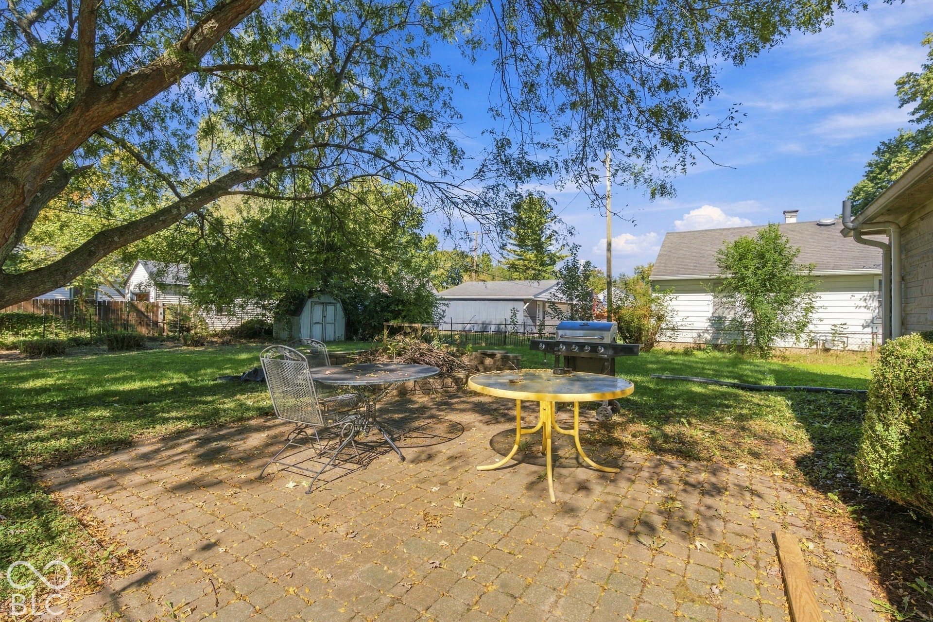 Paver patio with a shaded area and mature trees
