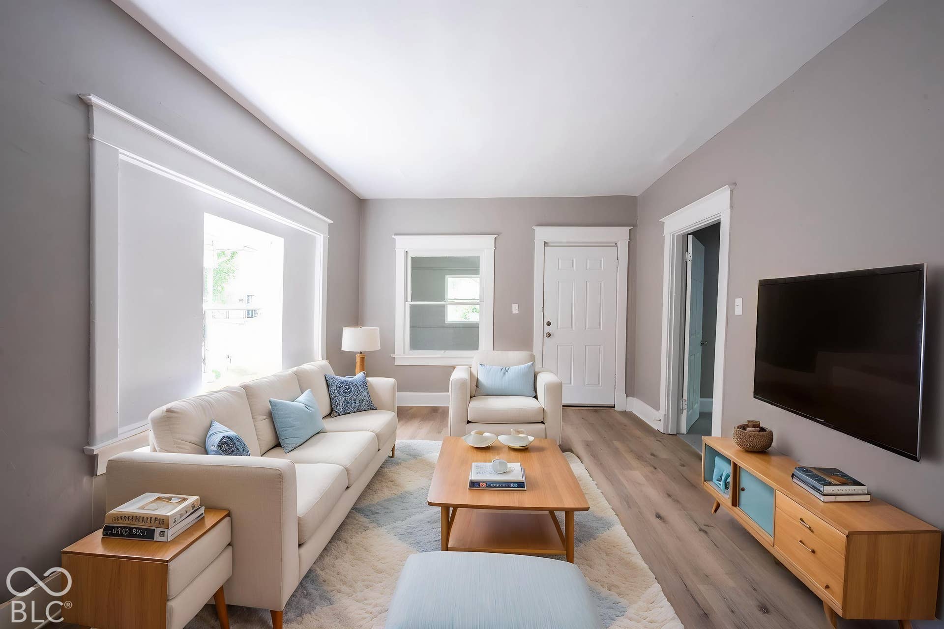 Light gray wall paint, wood-finish flooring, white window trim, white door, and recessed lighting