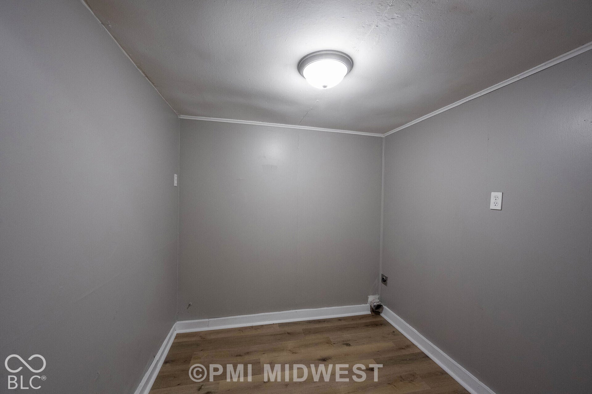 Recessed ceiling light fixture, crown molding, wood-finish flooring, and light gray wall finish