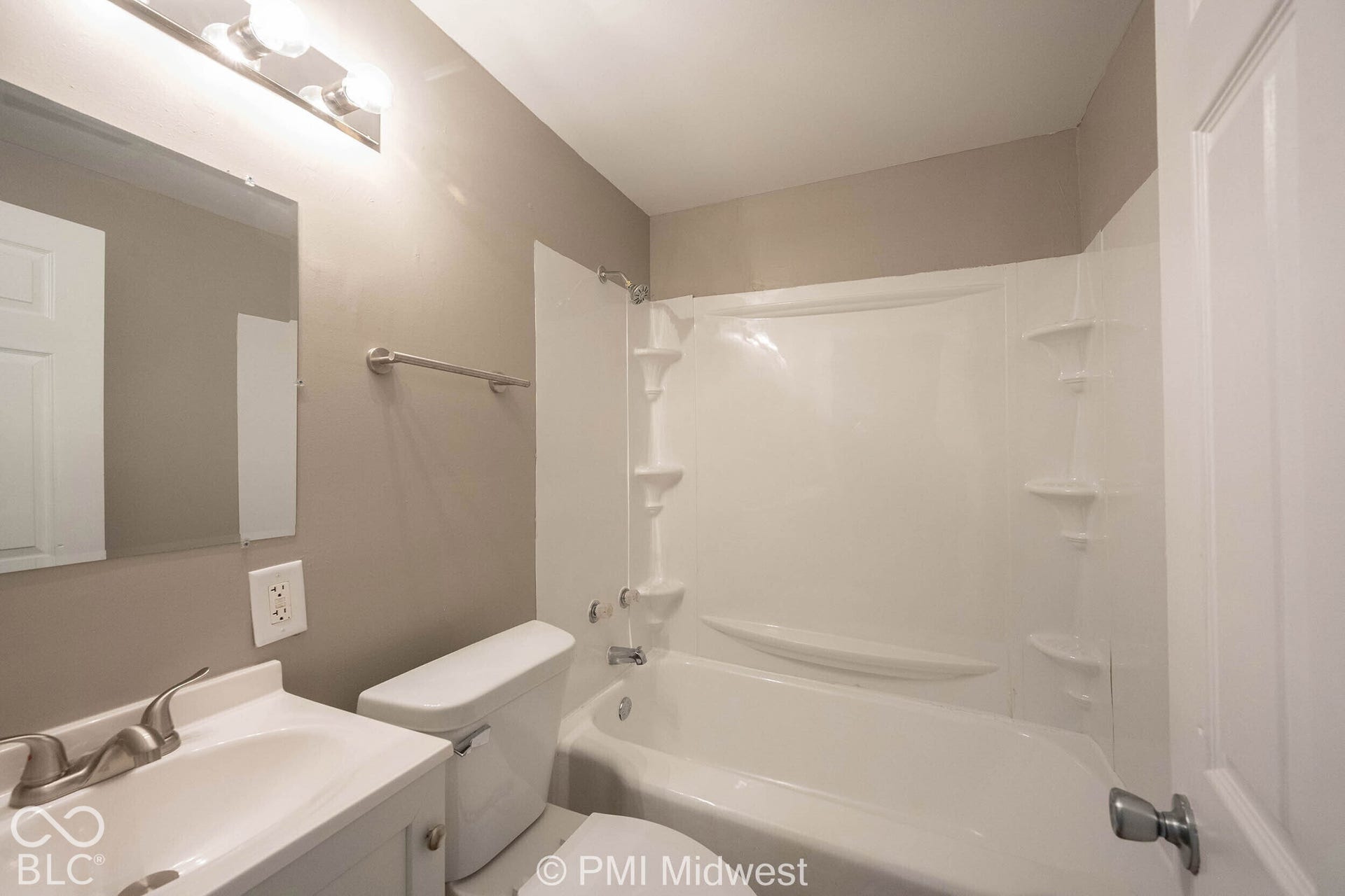 White vanity with integrated sink, brushed nickel faucet, and overhead vanity lighting