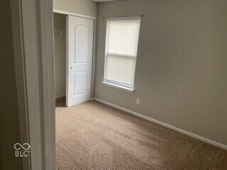 Carpeted flooring, neutral wall color, window with blinds, bi-fold closet doors