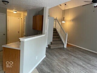 Wood-finish flooring with a neutral wall color, vaulted ceilings, and a ceiling fan