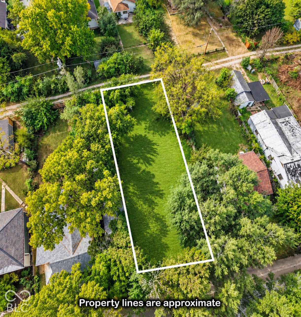 Expansive lot featuring mature trees and a substantial grassy area