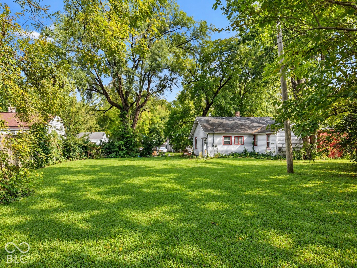 Expansive grassy yard with mature trees