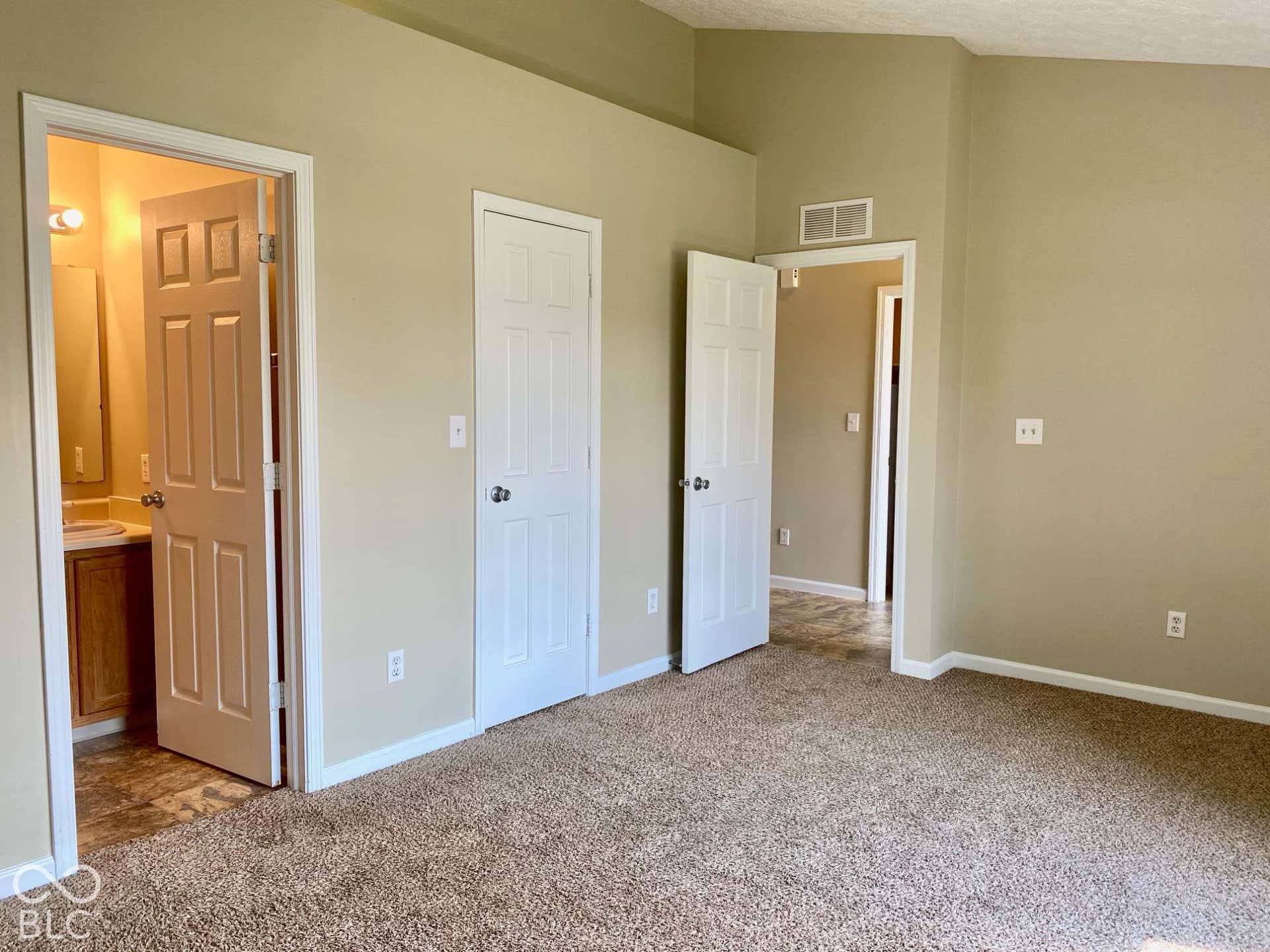 3911 Bonn Drive, Indianapolis, IN 46228 Carpeted flooring, vaulted ceiling, and white trim throughout