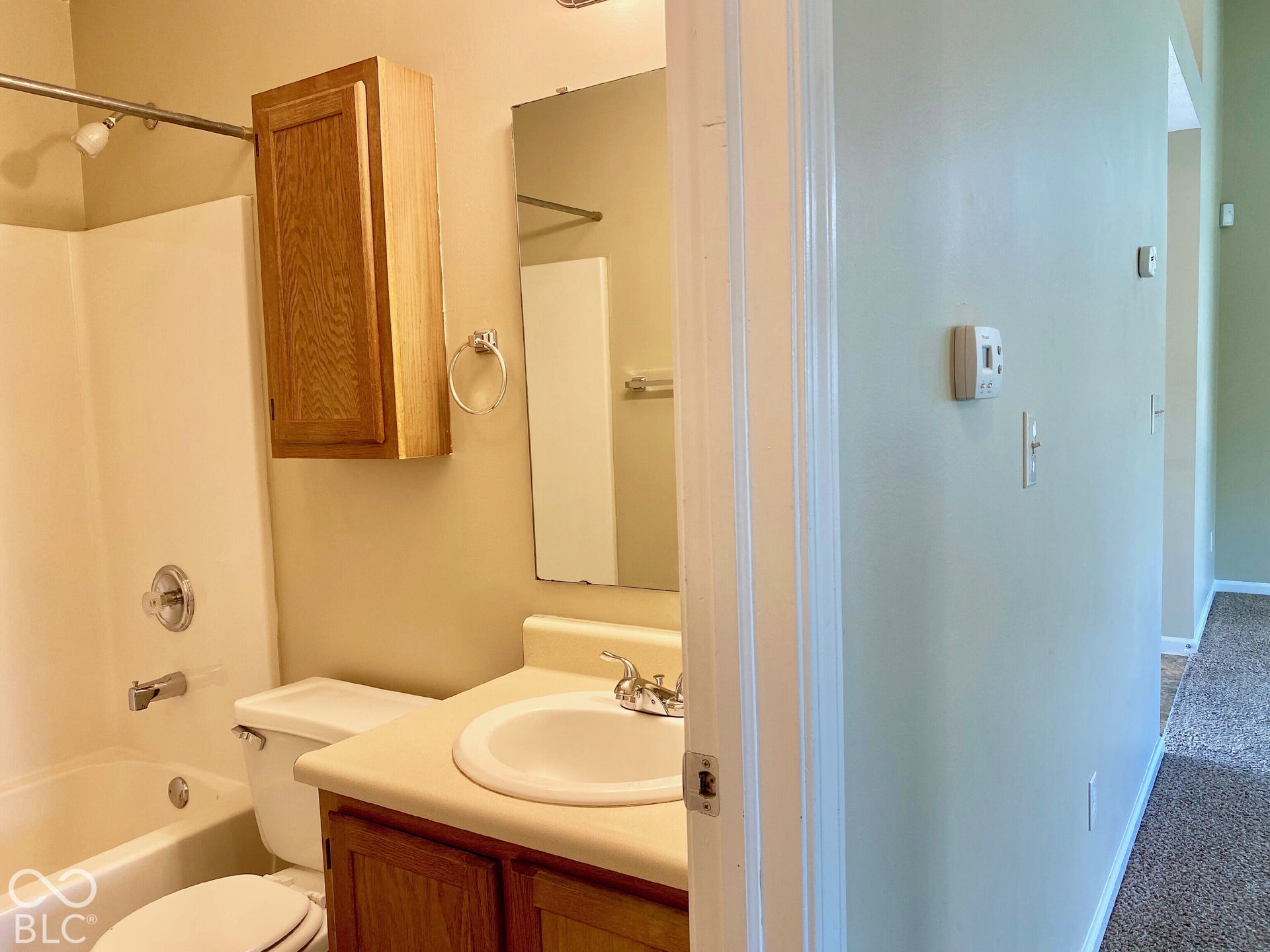 3911 Bonn Drive, Indianapolis, IN 46228 Full bathroom featuring a tub/shower combination with chrome fixtures, wood-finish vanity, and wall-mounted wood-finish cabinet