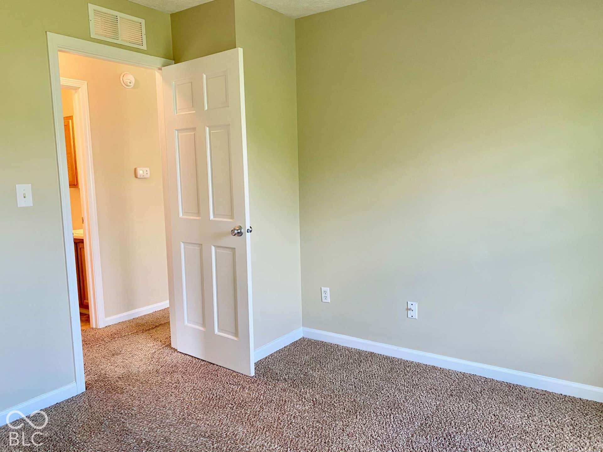3911 Bonn Drive, Indianapolis, IN 46228 Textured carpet flooring, neutral wall color, white trim, and a paneled interior door