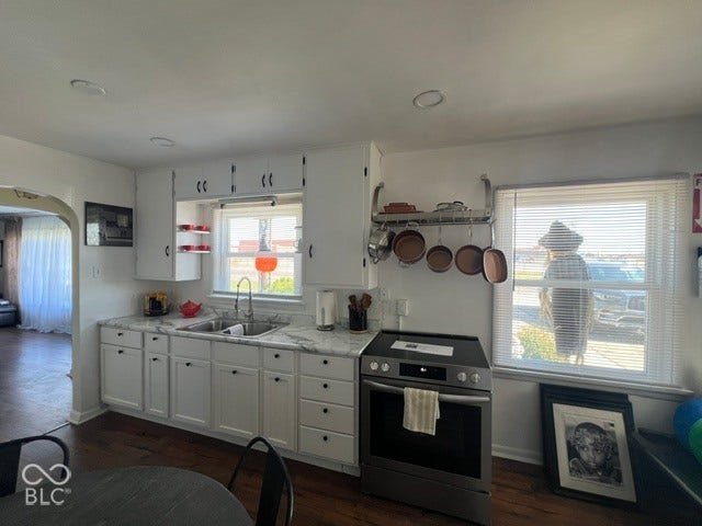 Kitchen featuring white cabinetry, integrated stainless steel sink, light-toned countertops