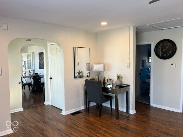 Laminate flooring throughout, arched doorway, recessed lighting, and white trim