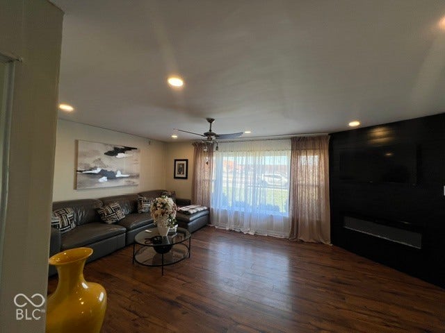 Laminate flooring, recessed lighting, ceiling fan, and a built-in media console