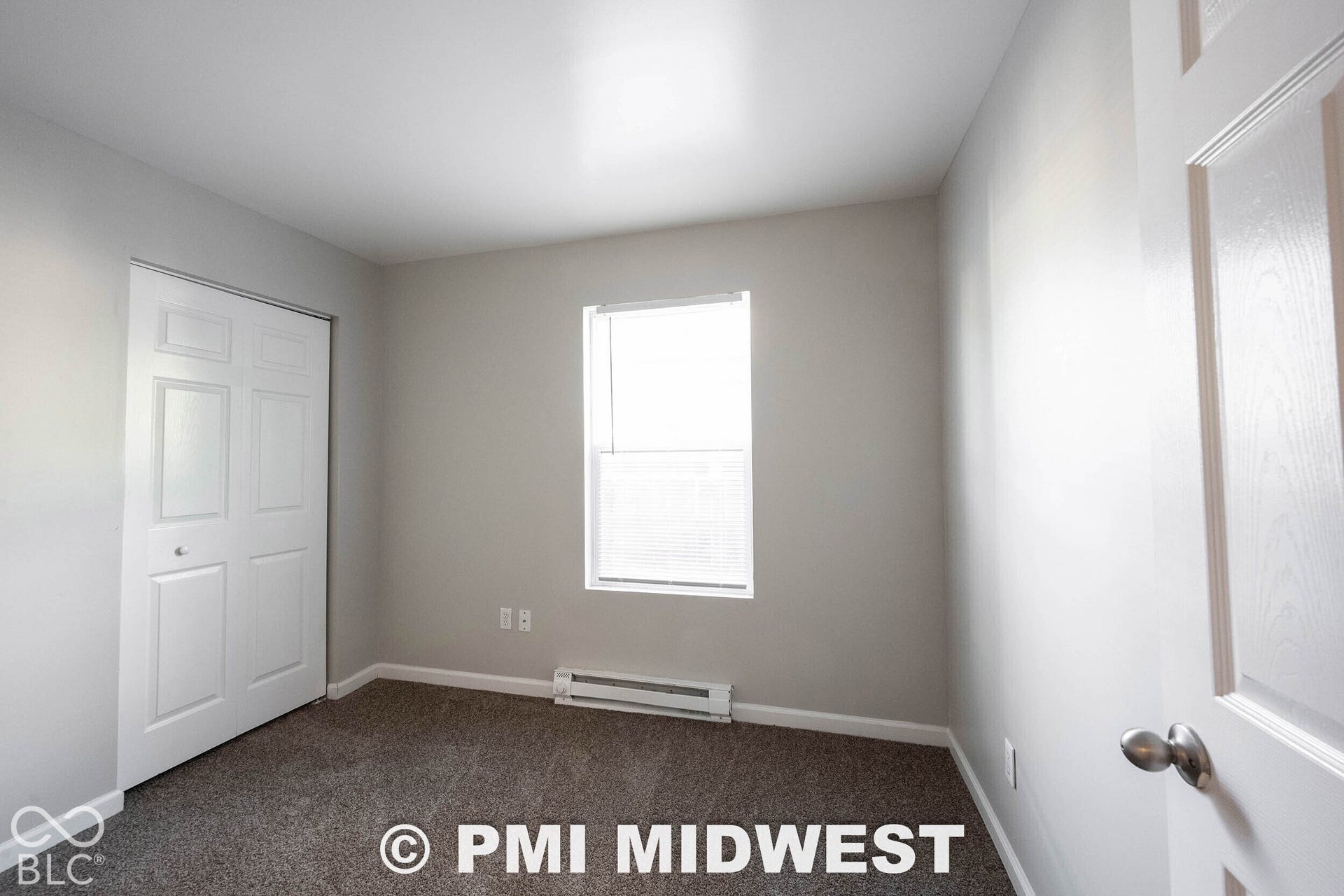 1122 Congress Avenue, Indianapolis, IN 46208 Neutral wall color, carpet flooring, a window with horizontal blinds, and a bi-fold closet door