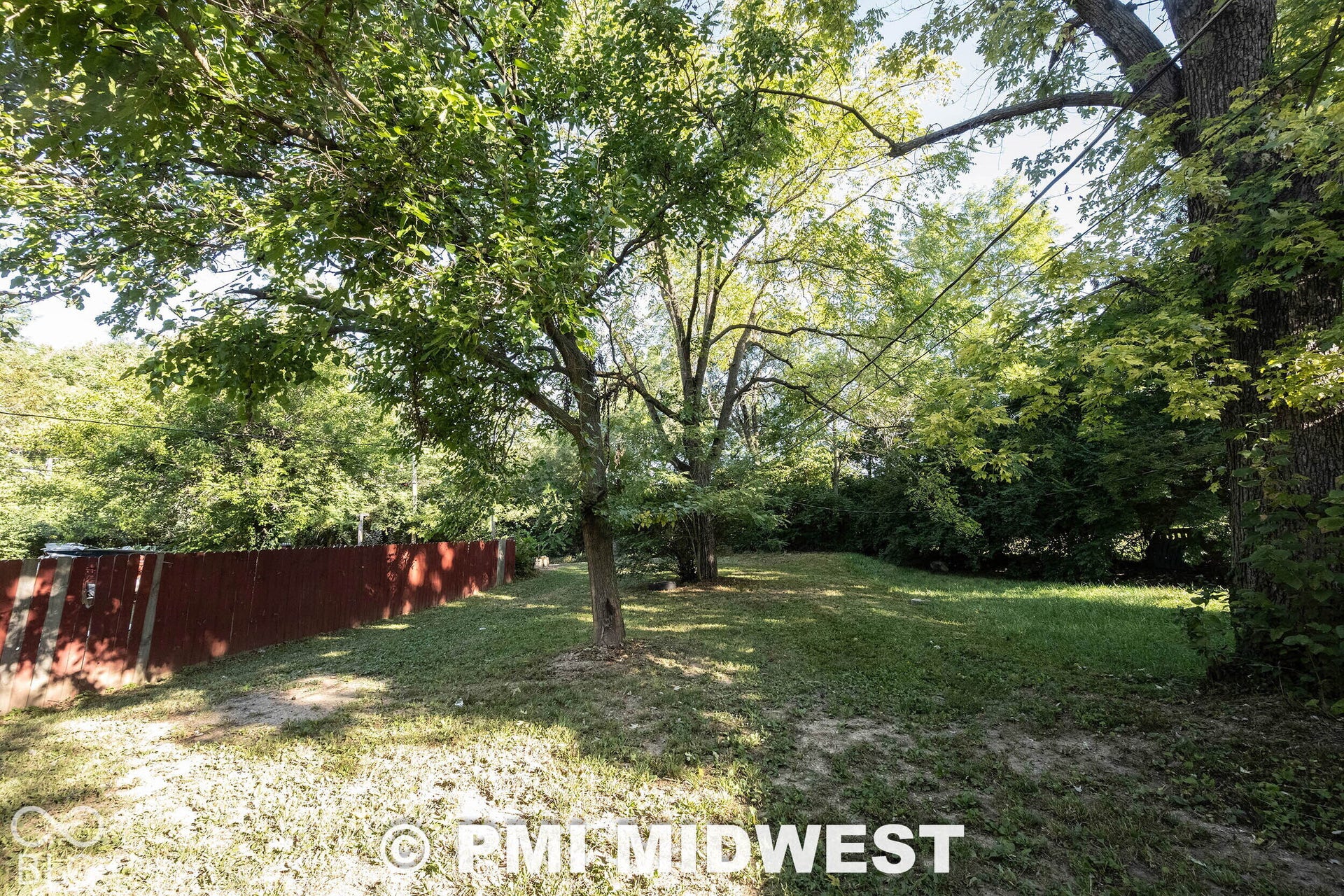 1122 Congress Avenue, Indianapolis, IN 46208 Expansive outdoor space featuring a mature tree canopy, manicured lawn, and a perimeter fence