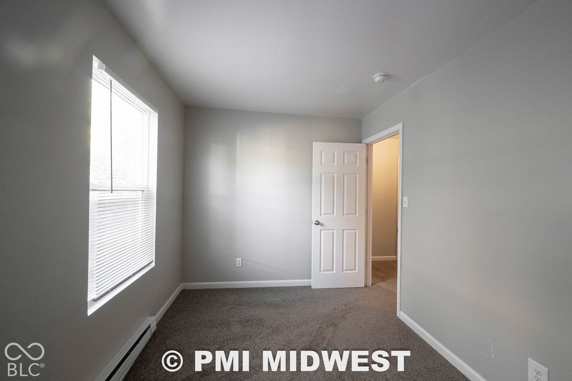 1122 Congress Avenue, Indianapolis, IN 46208 Carpeted flooring, light grey wall paint, single window with blinds, white paneled door, and white trim