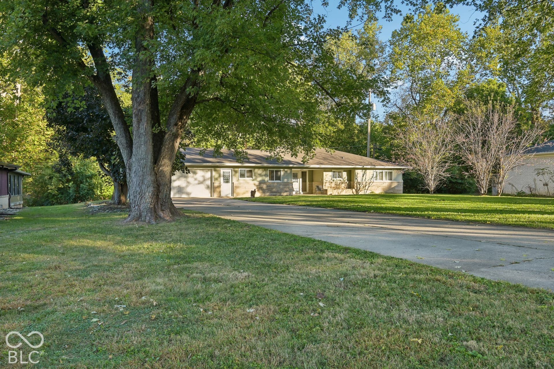Ranch-style residence featuring a light-colored brick exterior, attached garage, and a concrete driveway