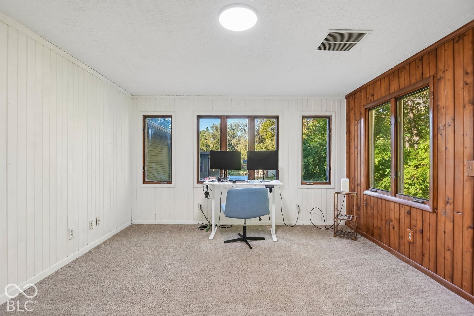 Room featuring a mix of painted vertical paneling and natural wood paneling