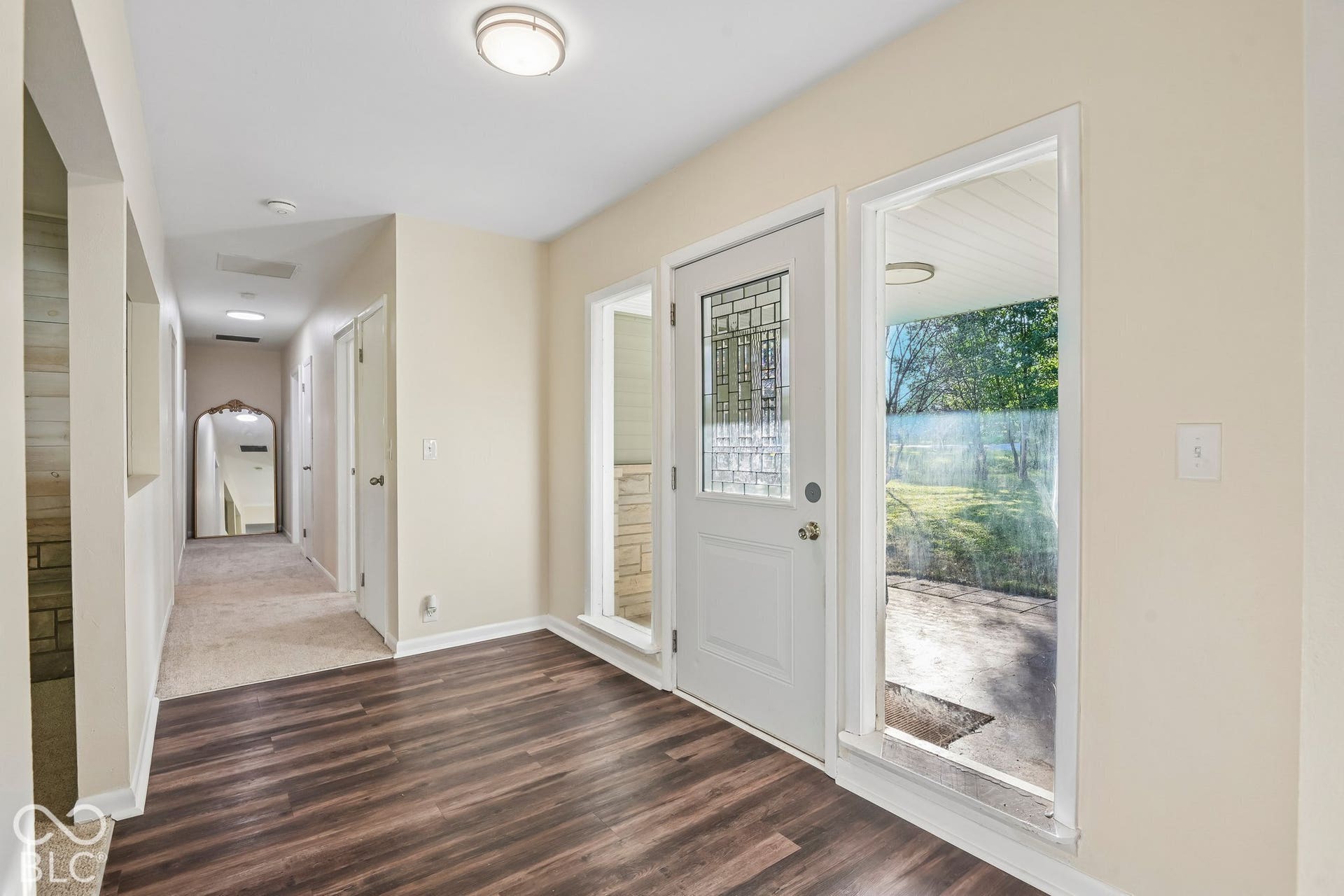 Entryway featuring wood-finish flooring, a decorative glass front door, and natural light