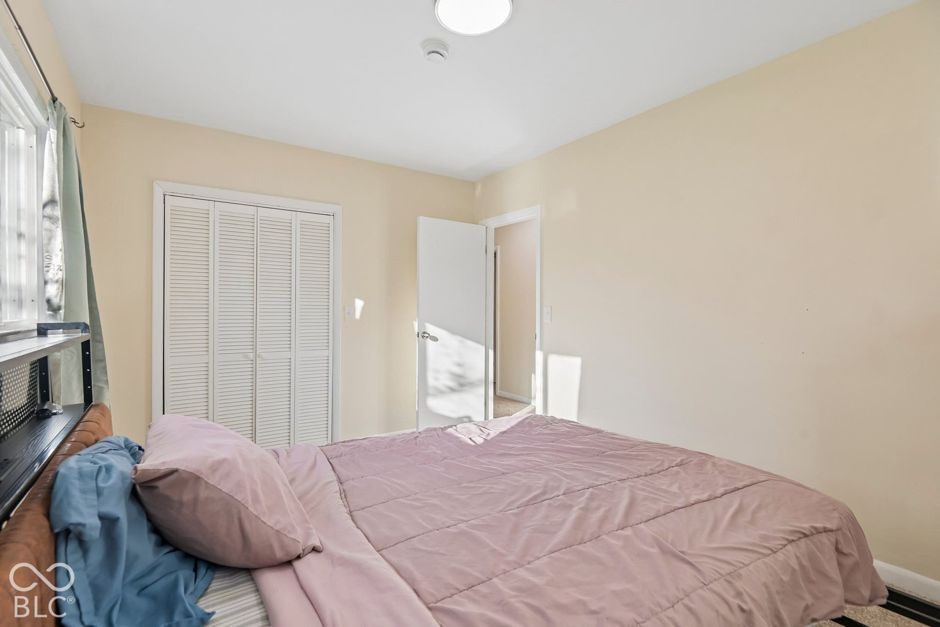 Window with natural light, bi-fold closet doors, and recessed ceiling lighting