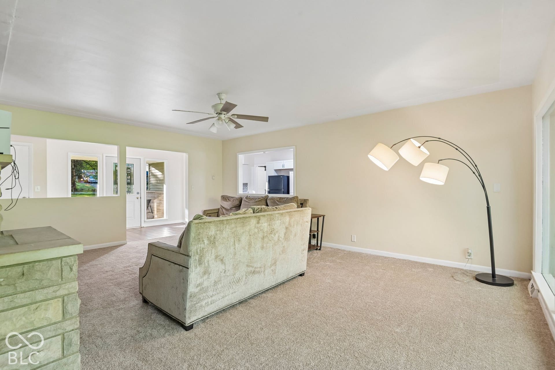 Light-toned carpeting, neutral wall paint, and a ceiling fan with integrated lighting
