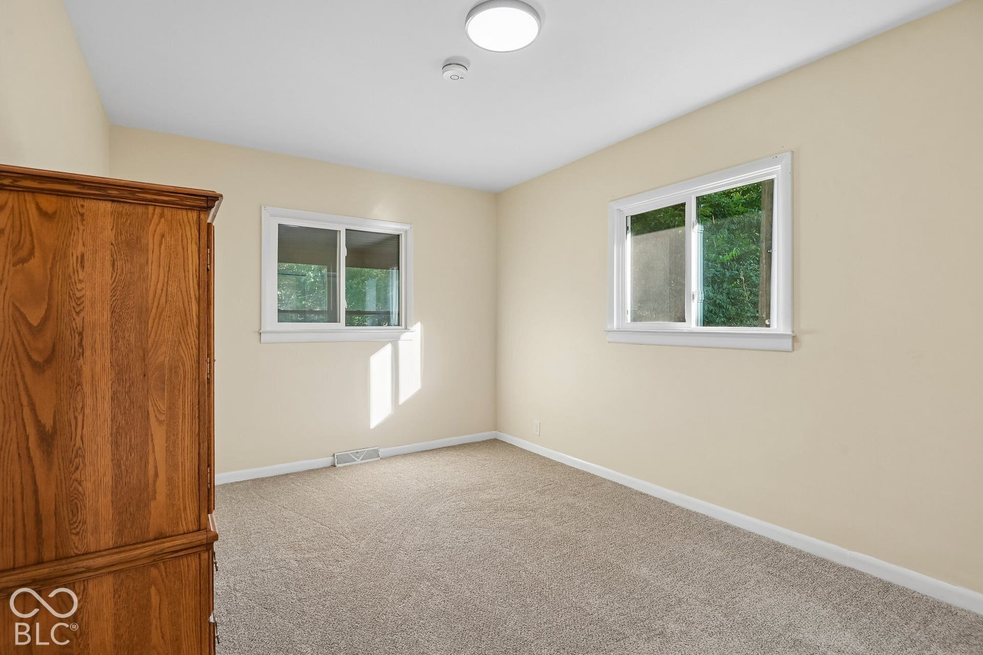 Bright, light-filled bedroom with dual windows providing natural illumination
