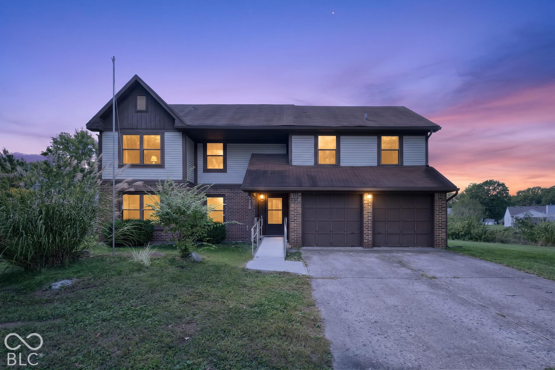 Virtually Altered - Two-story residence featuring light siding and brick accents