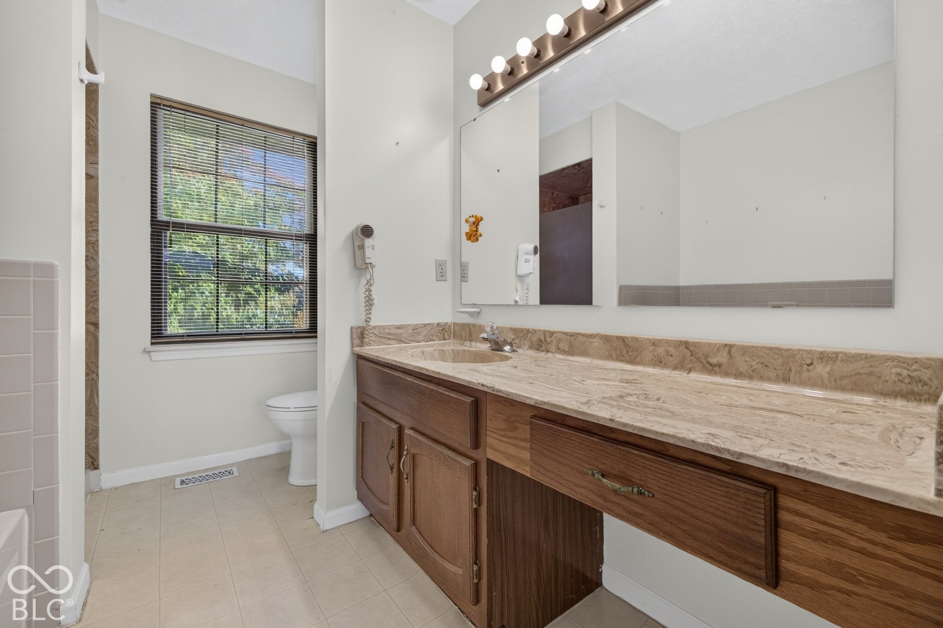 Extended vanity with an integrated sink and warm-toned countertop