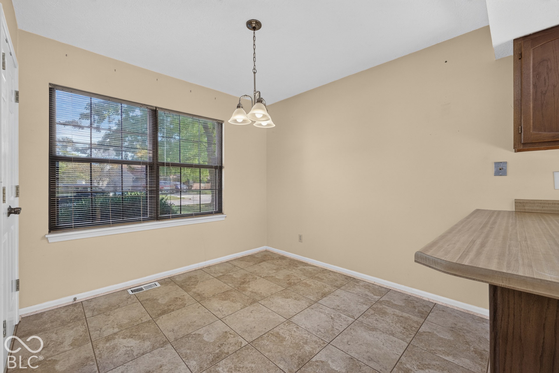 Tiled flooring, double window with blinds, overhead lighting fixture, and a built-in counter