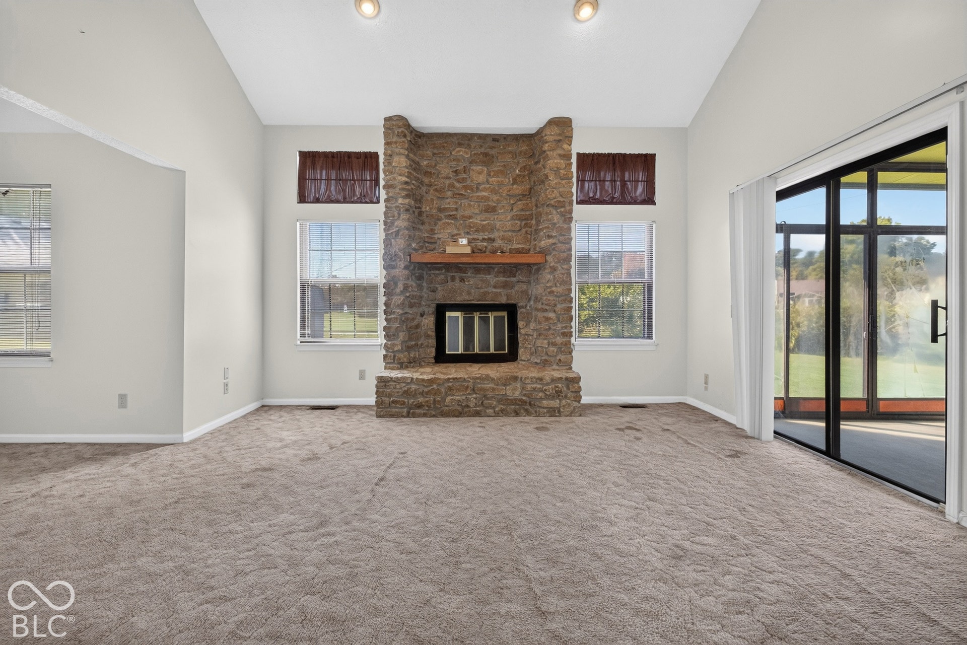 Central stone-clad fireplace with wood mantle