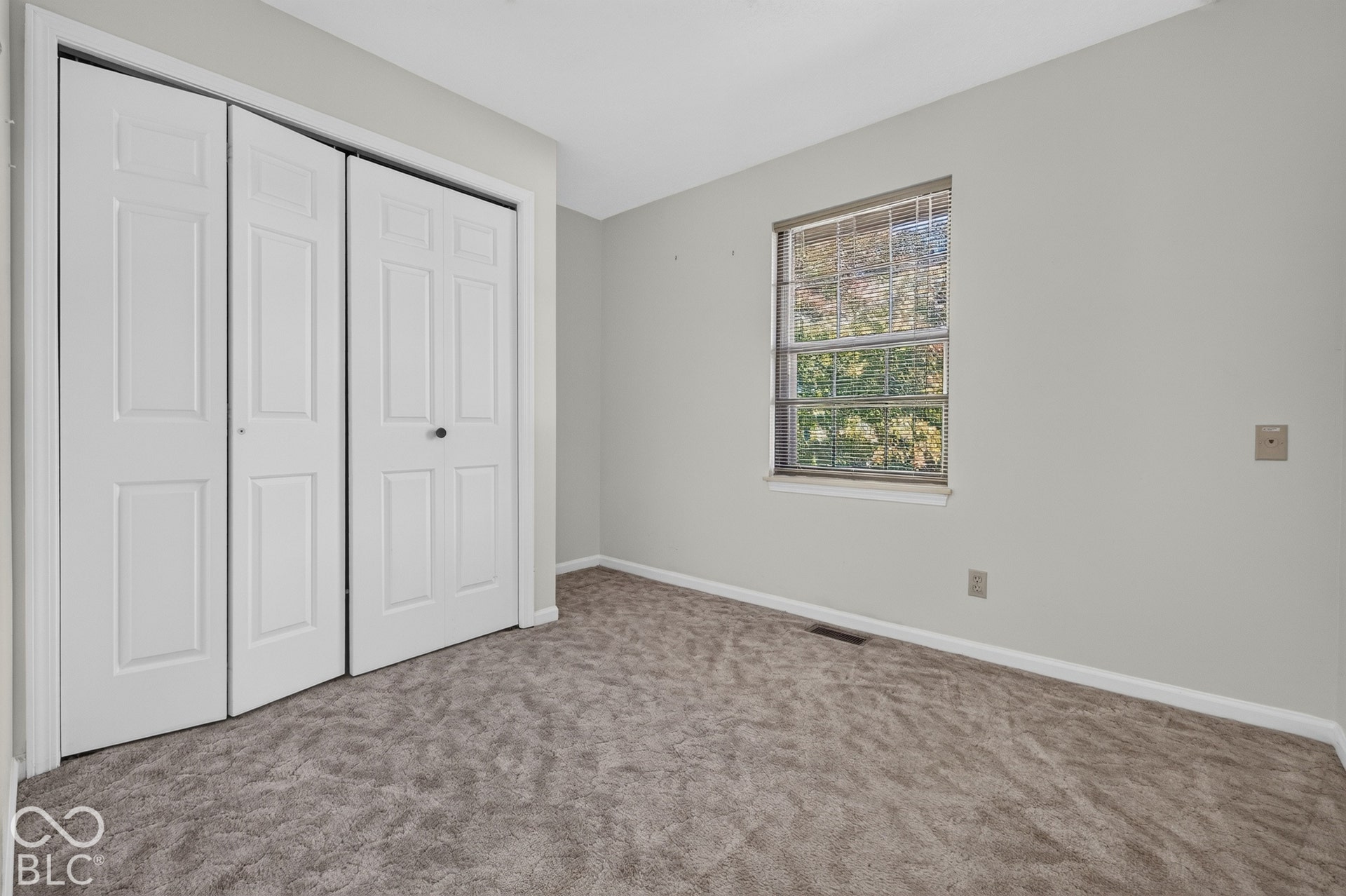 Carpeted flooring, white trim, light gray painted walls, and a multi-pane window