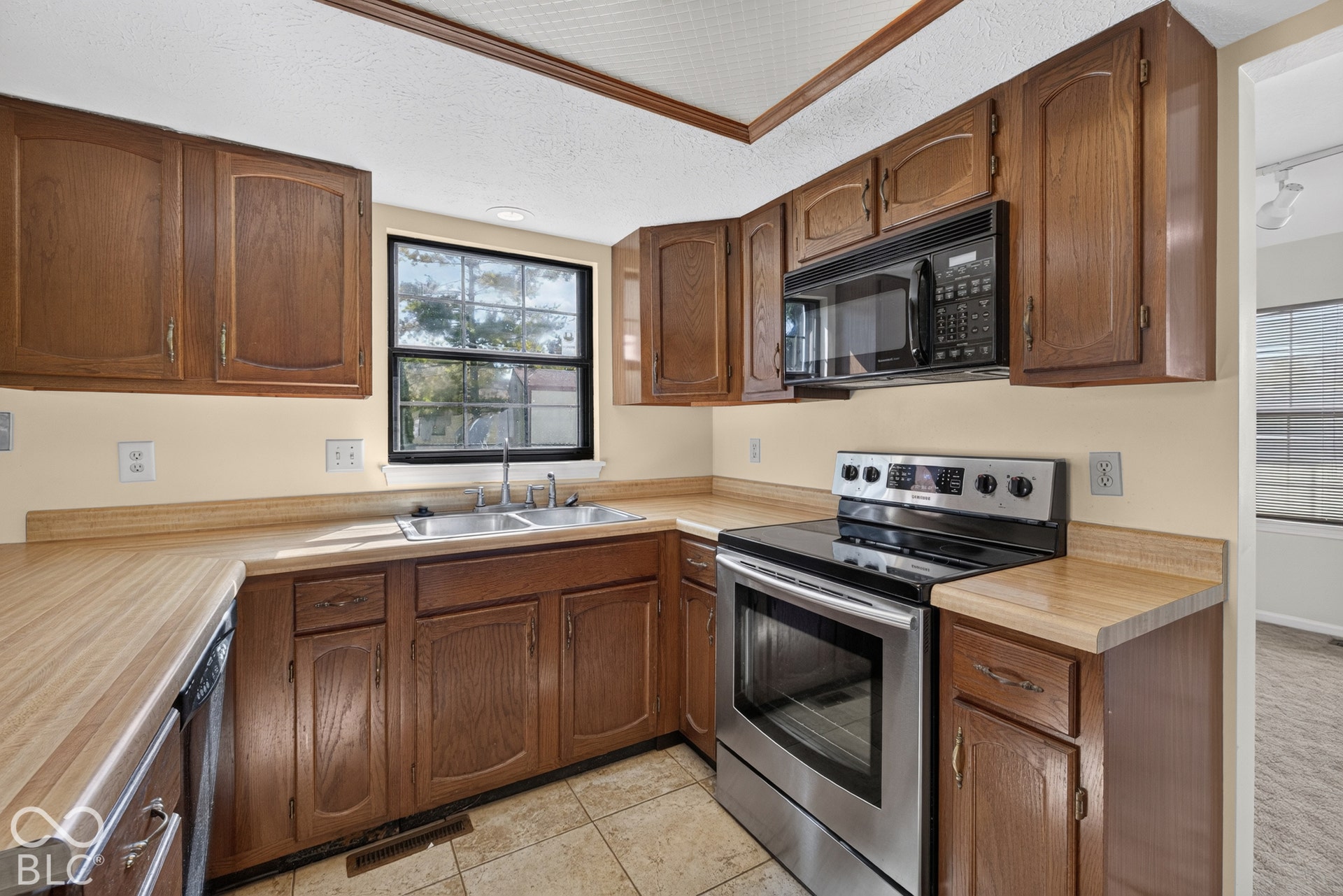 Kitchen featuring wood cabinetry, laminate countertops, a stainless steel range, and a built-in microwave