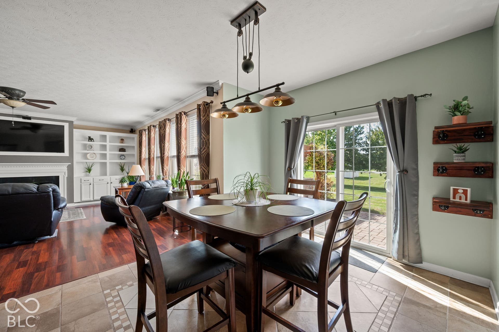 Spacious interior with wood-finish flooring, a contemporary ceiling fan, and built-in shelving