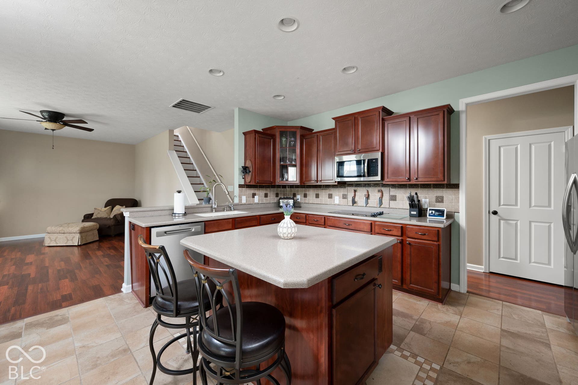 Kitchen featuring wood cabinetry, stainless steel microwave, and a tile backsplash