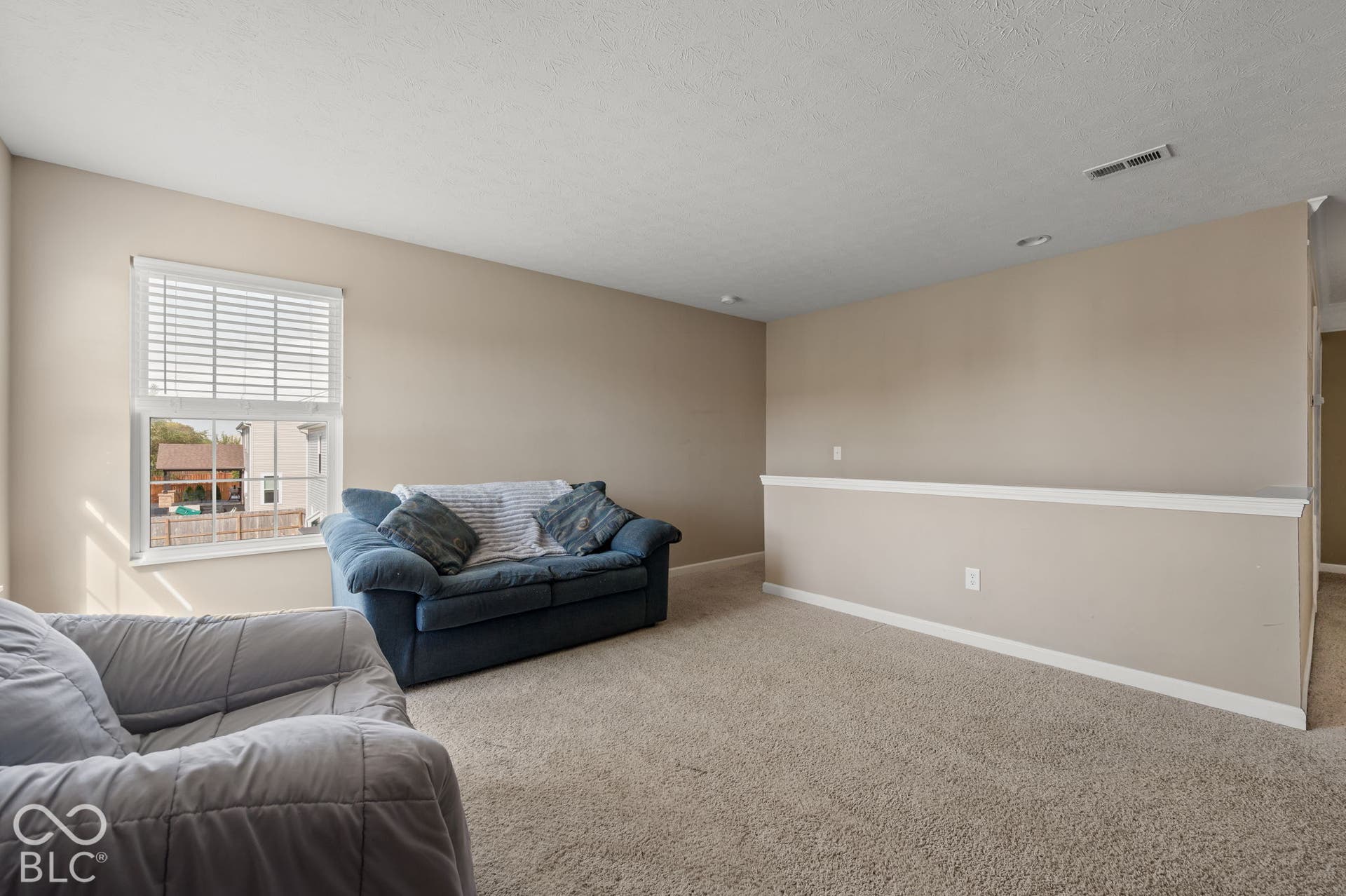 Carpeted floor, neutral wall paint, recessed lighting, white window blinds, and a partial wall with white trim
