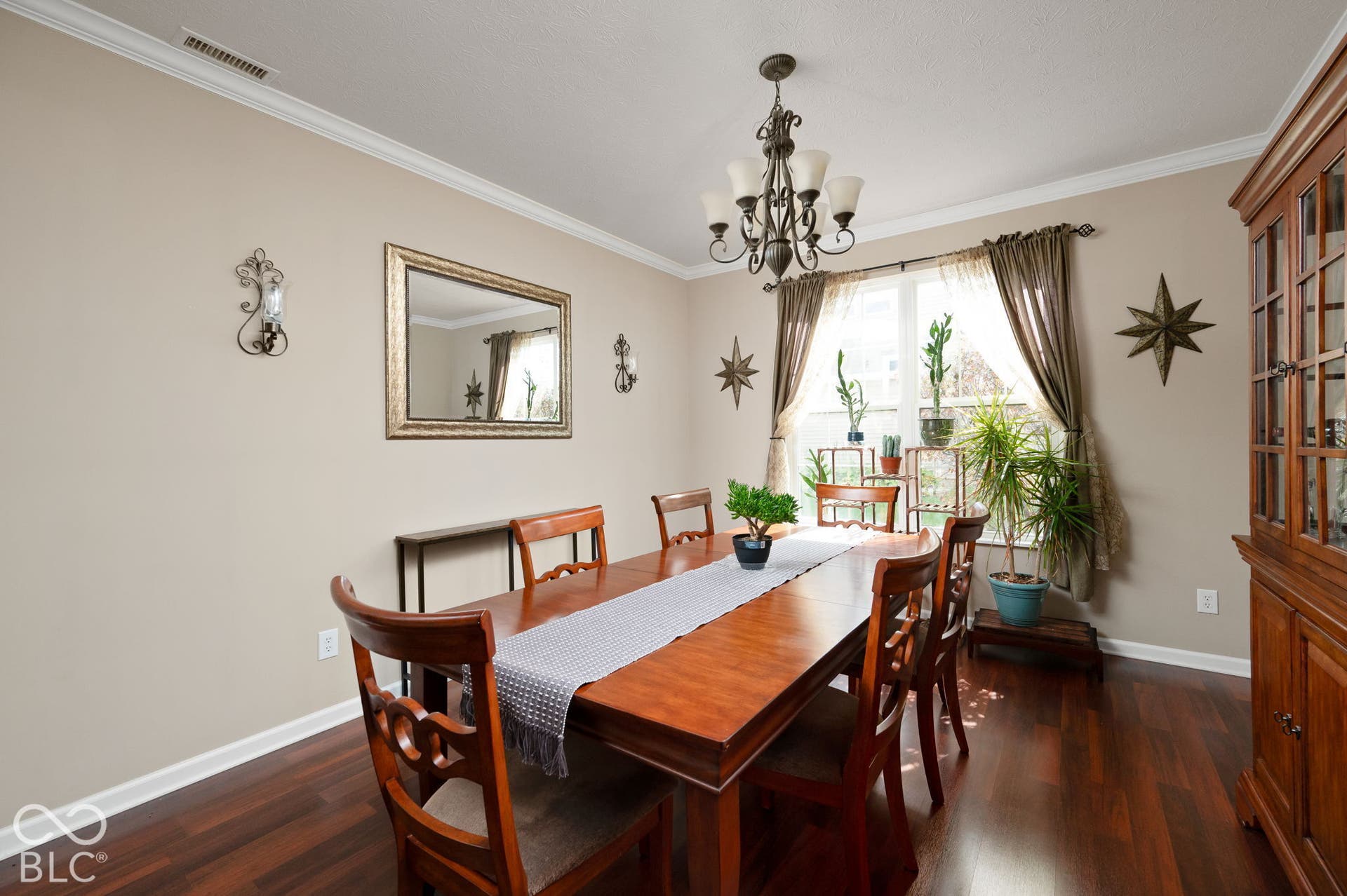 Hardwood-finish flooring, crown molding, and a bronze chandelier