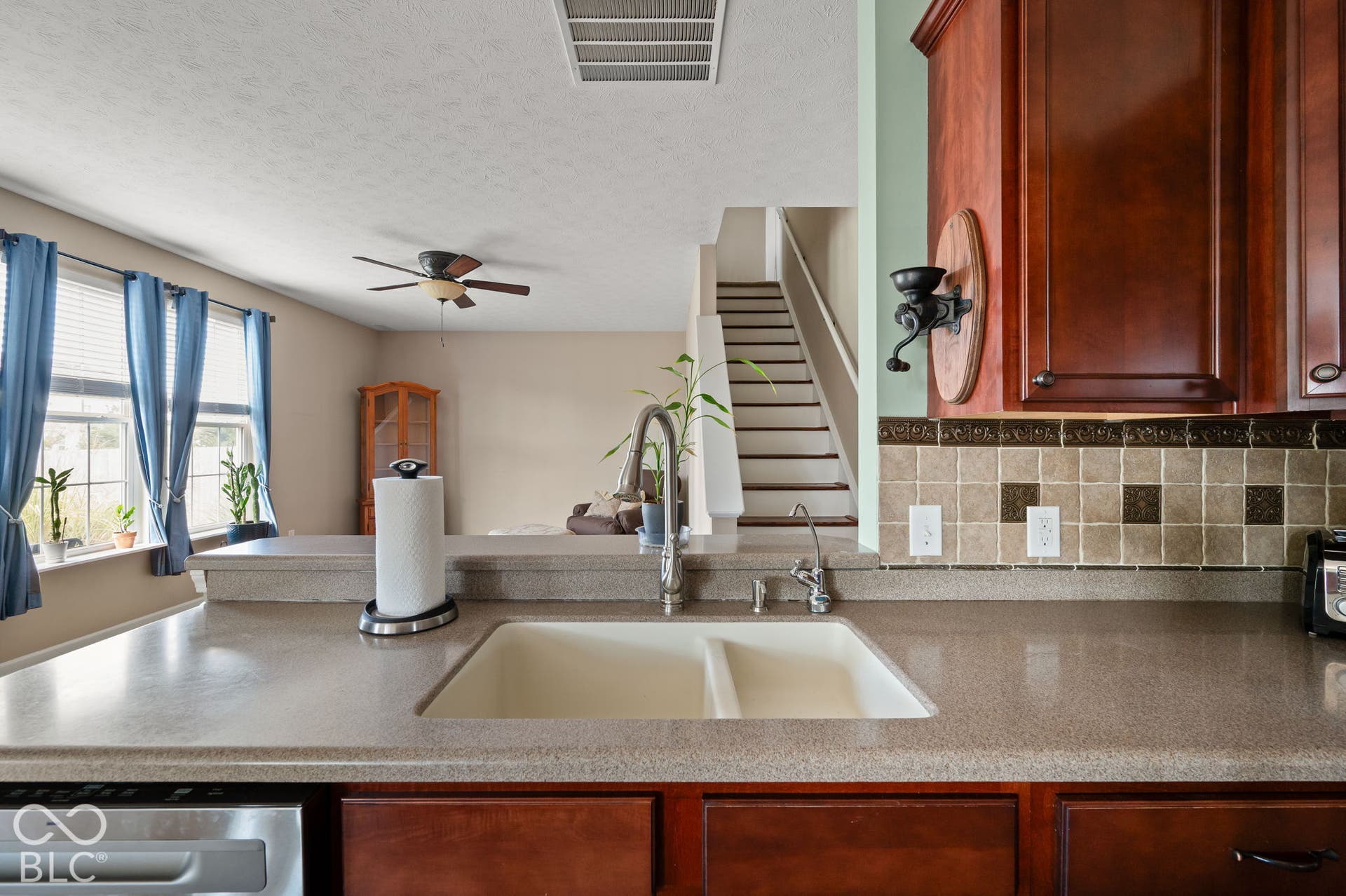 Dual basin sink with a high-arch faucet, set in a light-toned countertop