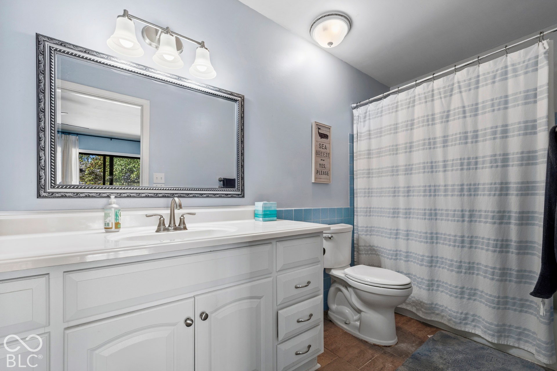 Spa-inspired bathroom featuring a white vanity with dual-sink configuration, polished nickel widespread faucet, and ample countertop storage