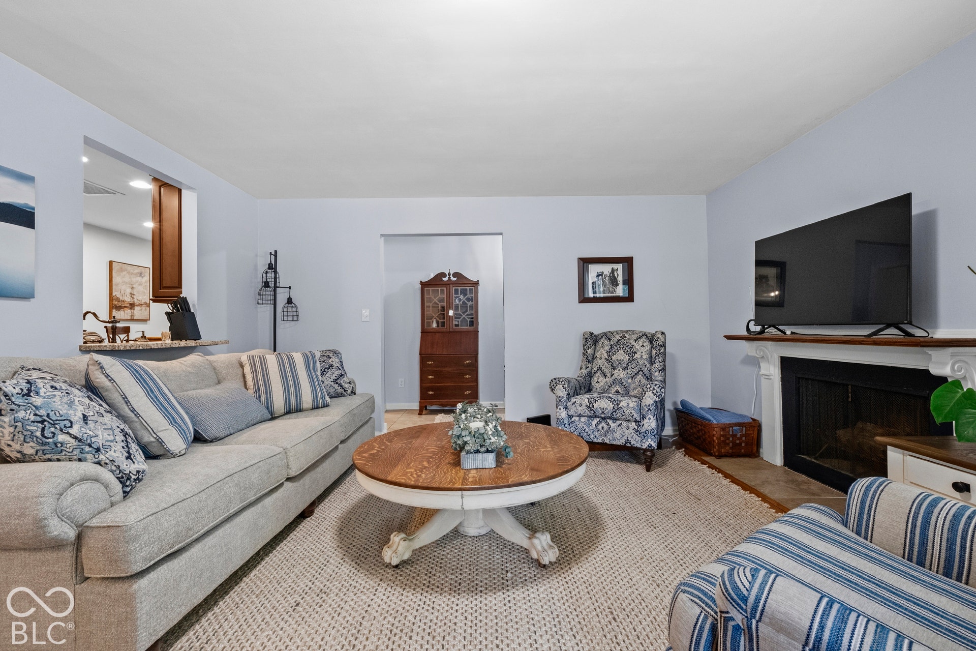 Integrated pass-through window with counter, built-in fireplace with mantel, and light-toned walls