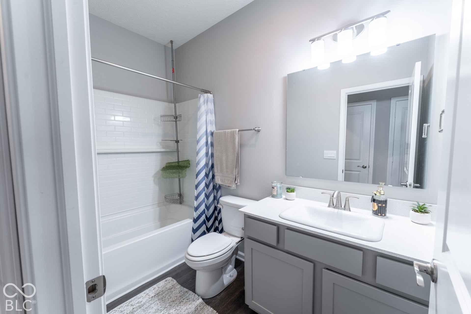 6432 Yuma, Whitestown, IN 46075 Tub and shower combination featuring white subway tile surround, vanity with gray cabinetry, white countertop, and rectangular mirror with overhead lighting