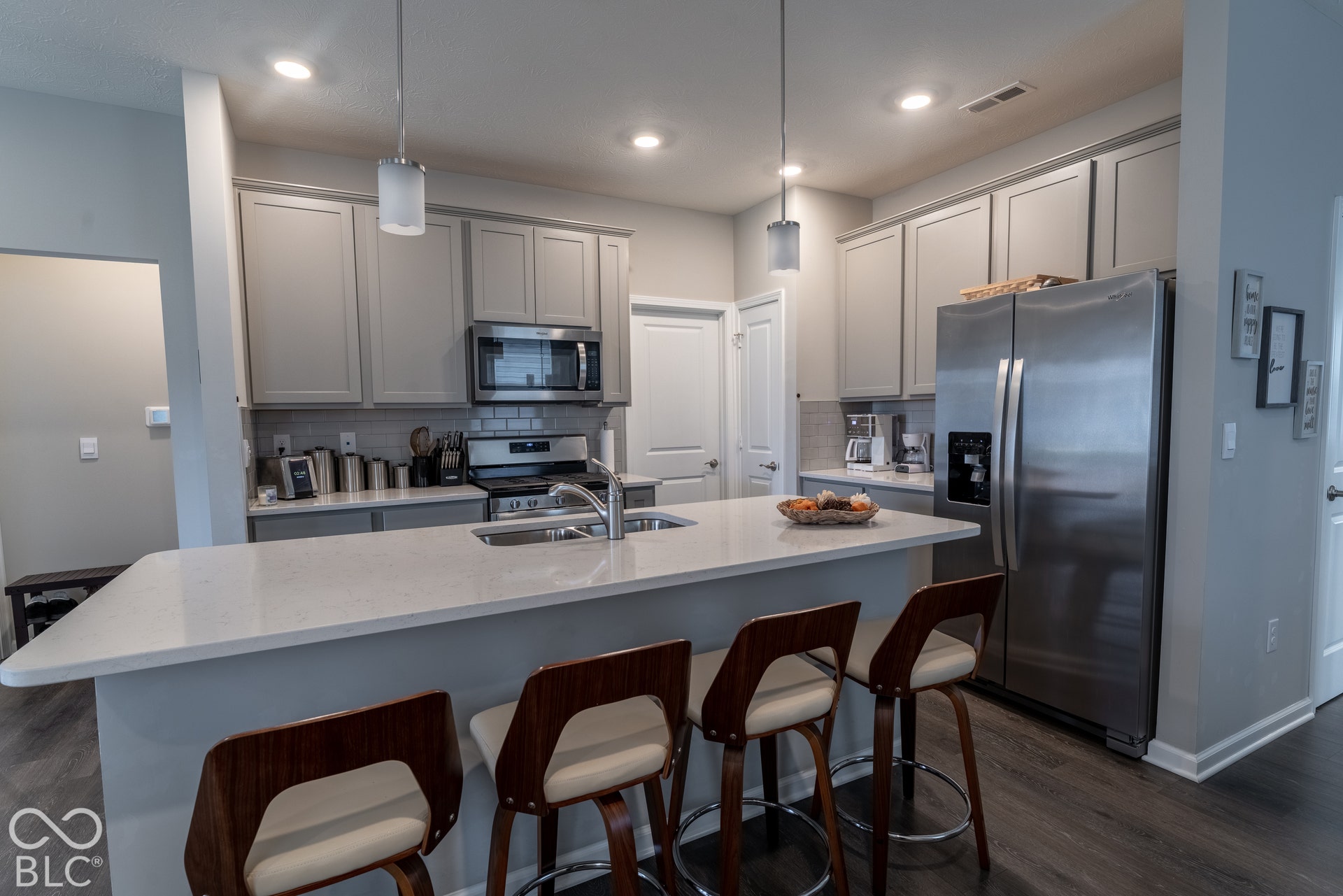 6432 Yuma, Whitestown, IN 46075 Kitchen featuring a large island with an undermount sink, stainless steel appliances, shaker-style cabinetry, and wood-finish flooring