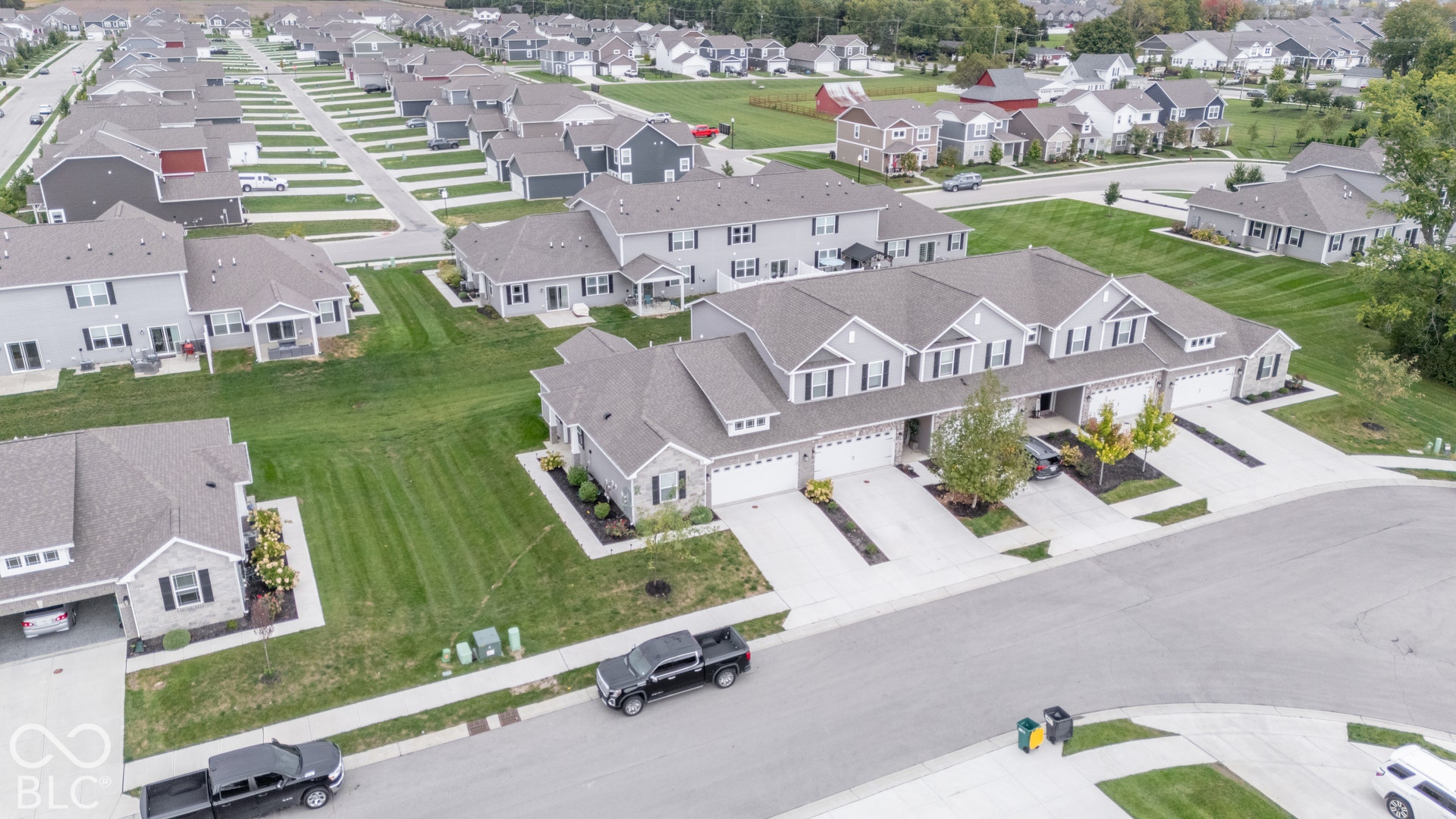 6432 Yuma, Whitestown, IN 46075 Row of townhomes featuring light gray siding, white trim, attached garages, and individual driveways