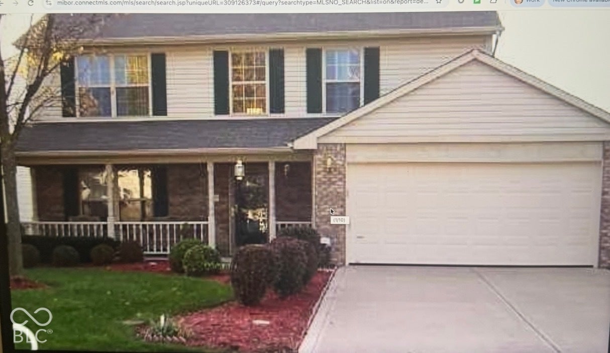 702 Coffee Tree, Indianapolis, IN 46224 Two-story property with brick and siding exterior, front porch with white railing, and an attached two-car garage
