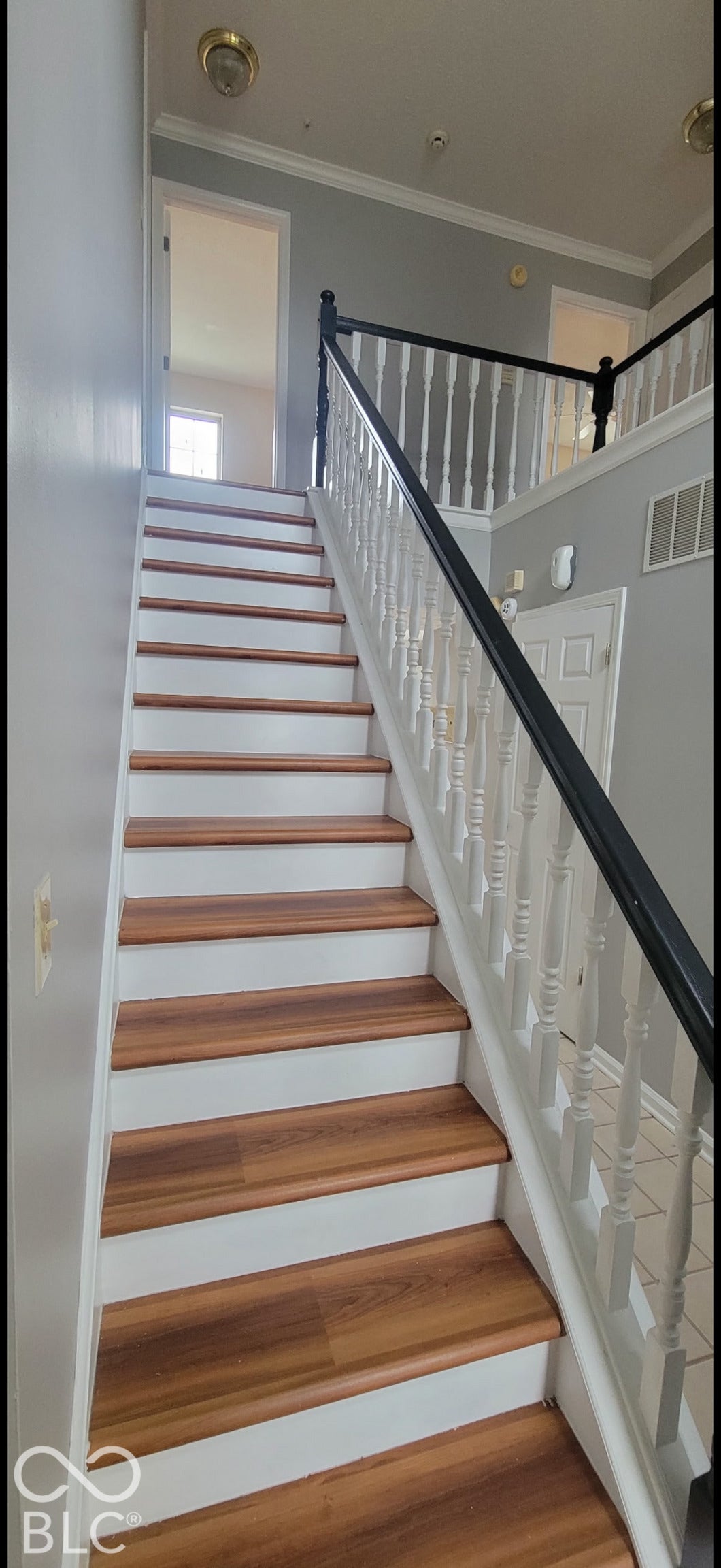 702 Coffee Tree, Indianapolis, IN 46224 Staircase with wood-finish treads and white risers, featuring a white balustrade with a dark handrail