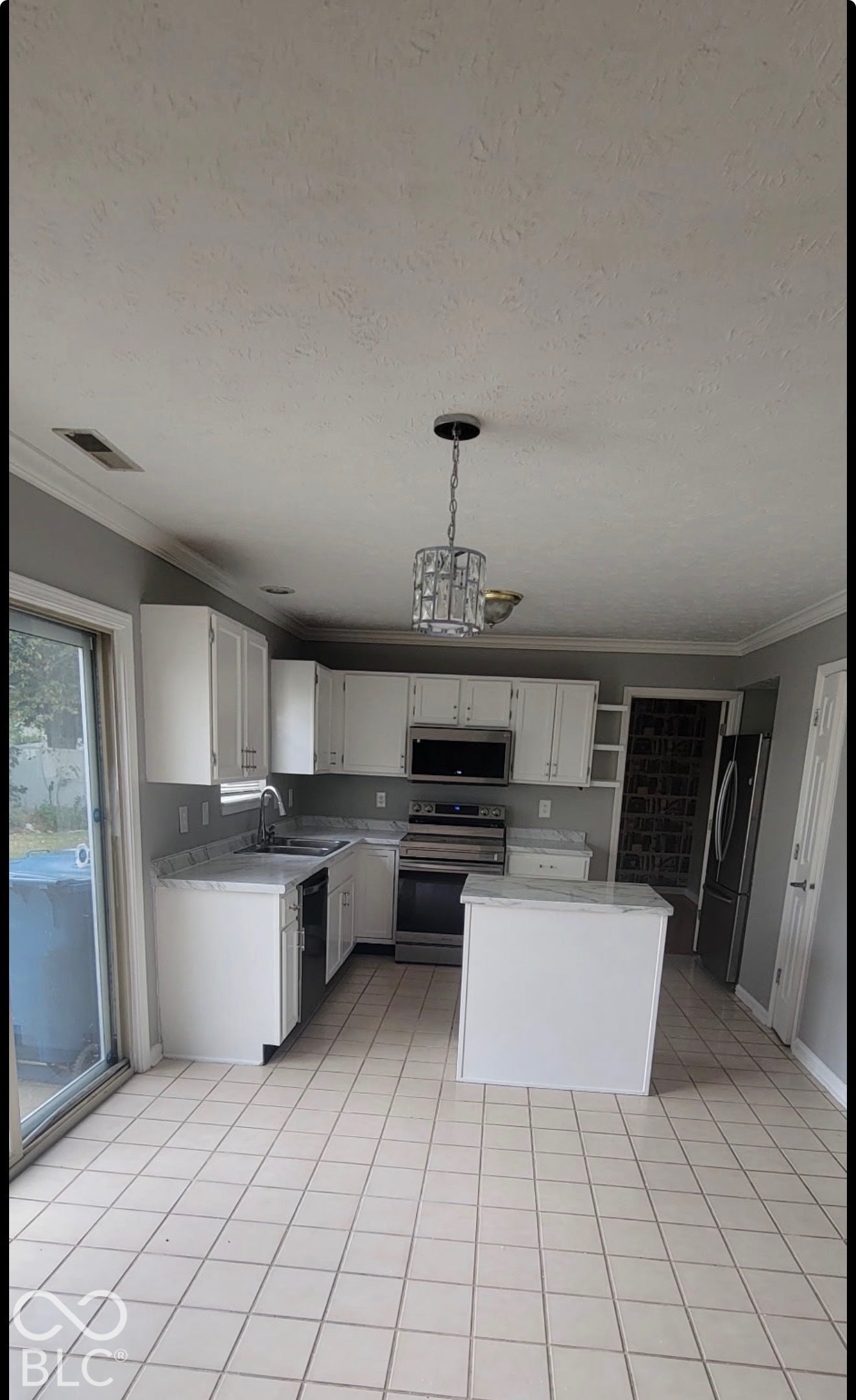 702 Coffee Tree, Indianapolis, IN 46224 Kitchen featuring white cabinetry, light-colored countertops, stainless steel appliances, a central island, and tile flooring