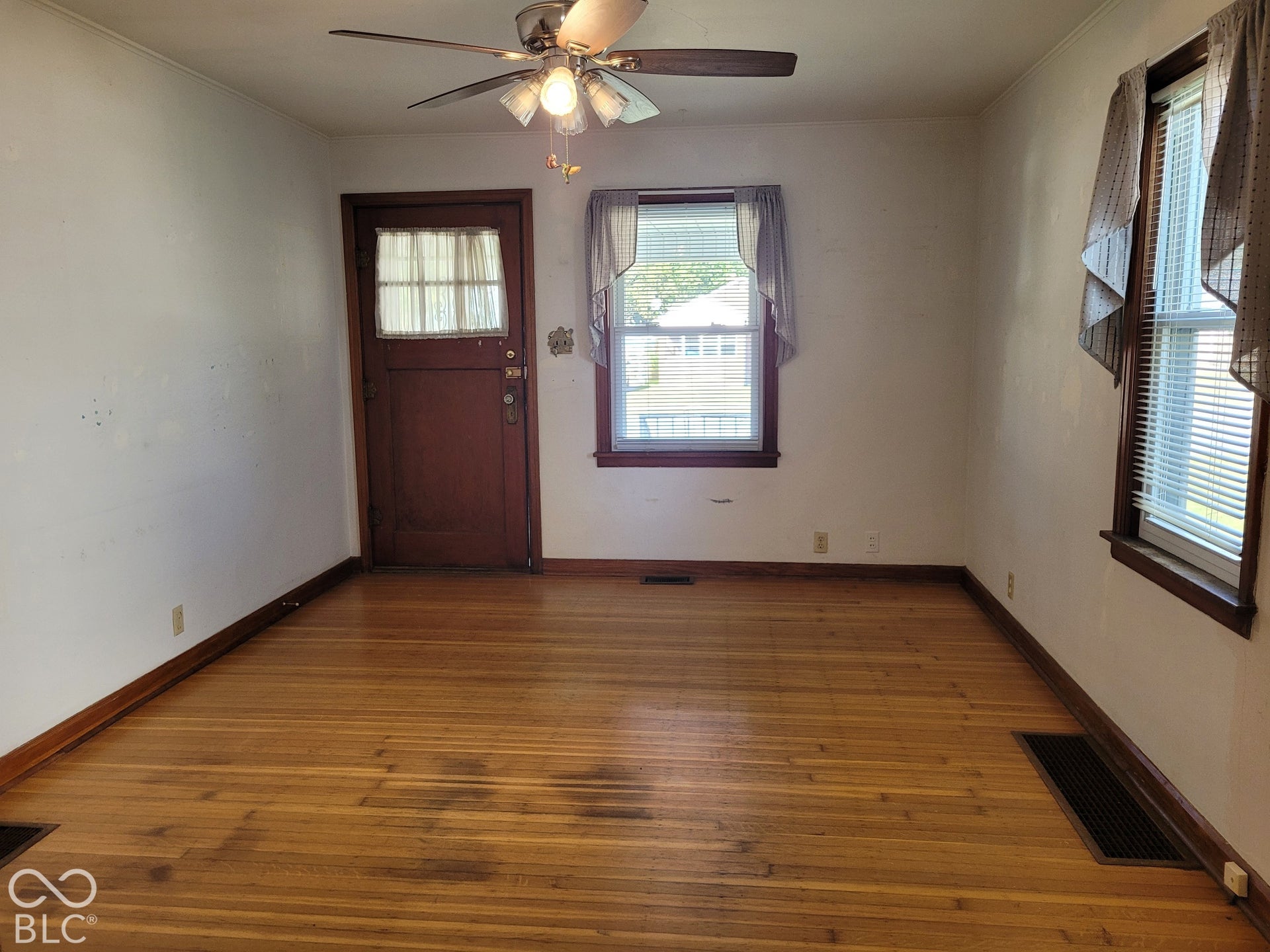 living room showing front door - - room is nice and bright with the two windows