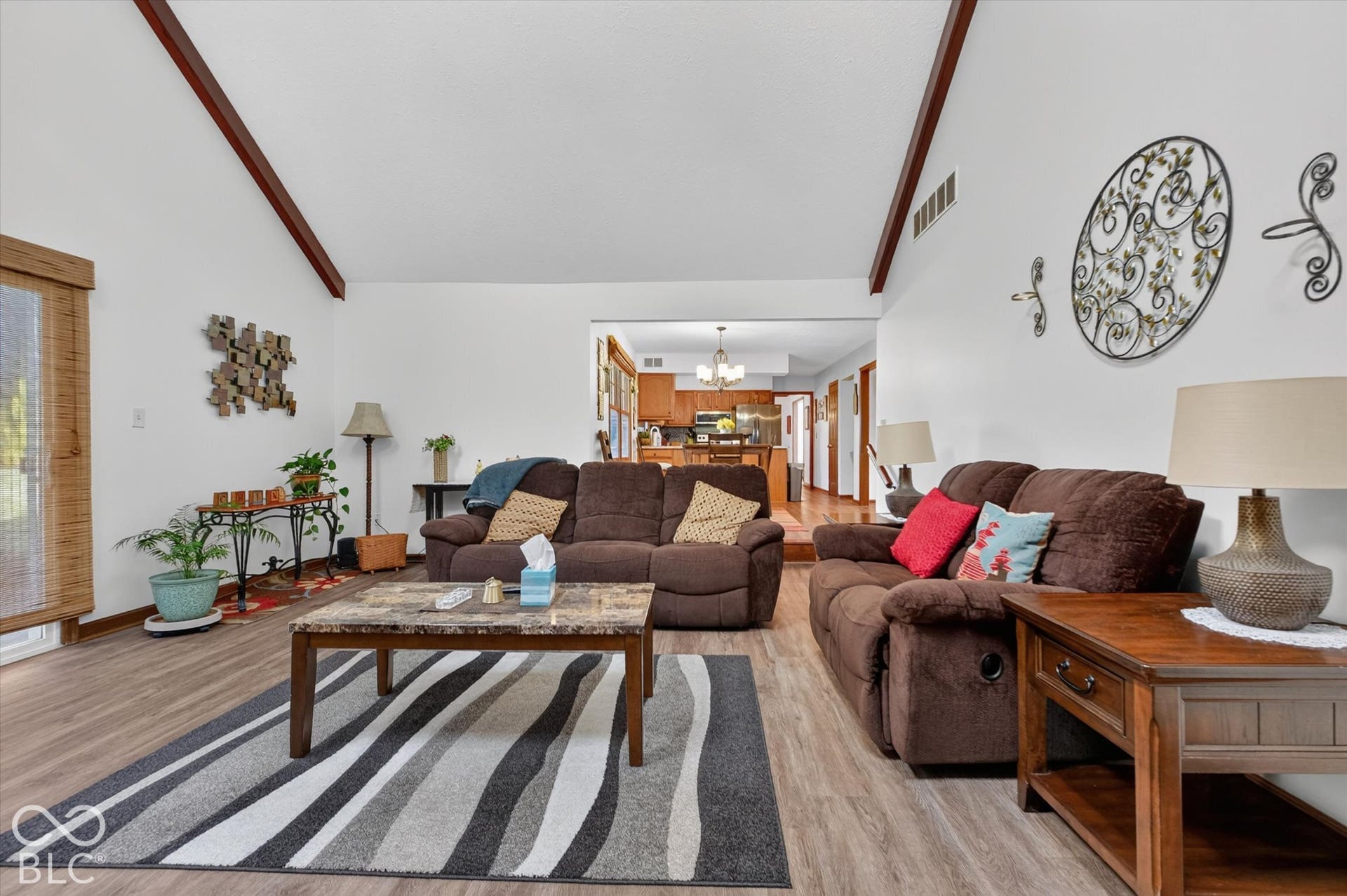 Vaulted ceilings with exposed wood beams, wood-finish flooring, and recessed lighting