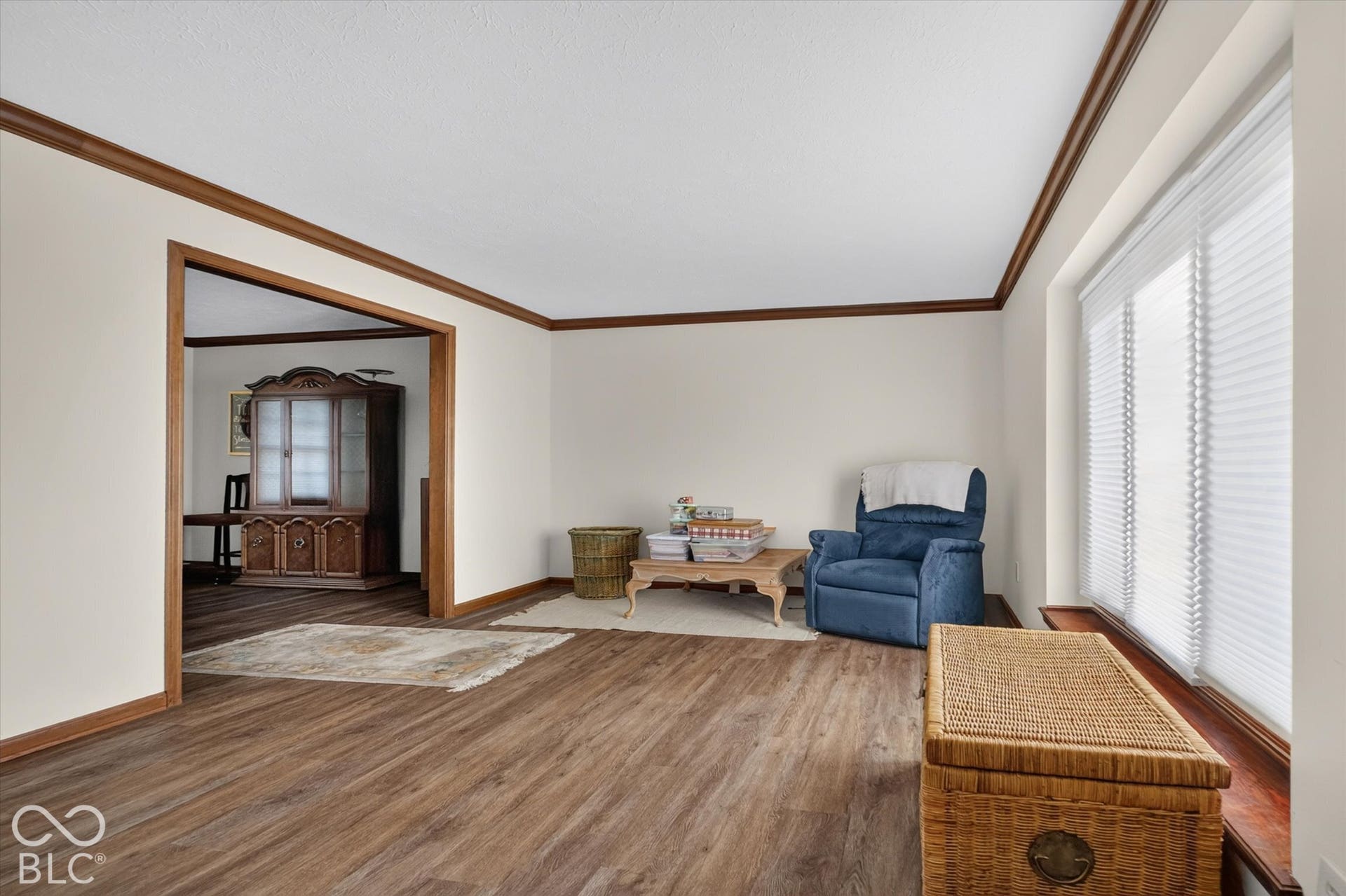 Wood-finish flooring throughout, bright walls, and rich wood trim