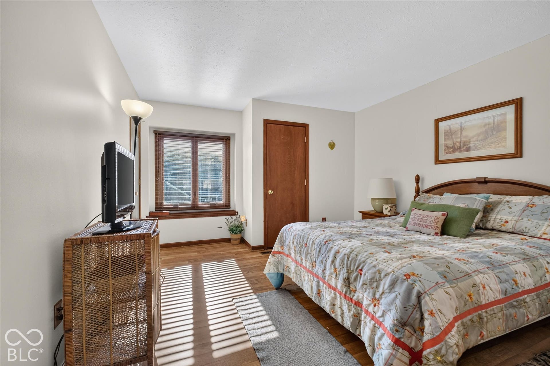Wood-finish flooring, light-toned walls, and a window with wood-finish trim and blinds