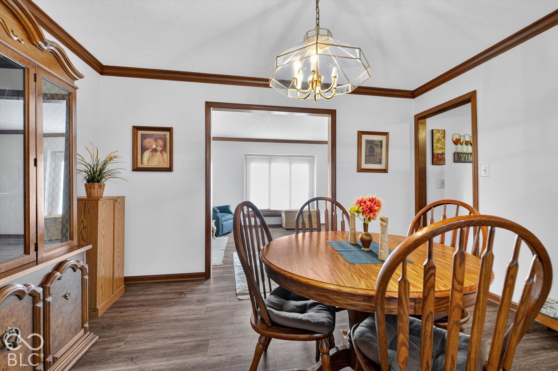Vaulted ceiling with a chandelier, wood-finish flooring, and wood trim throughout