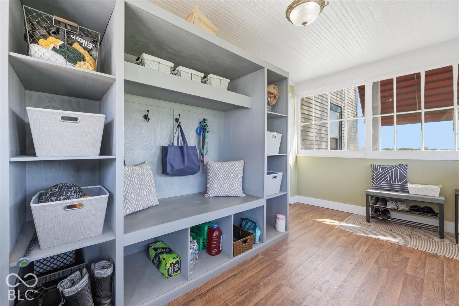 Built-in storage solutions with shelving, integrated bench seating, and wood-finish flooring