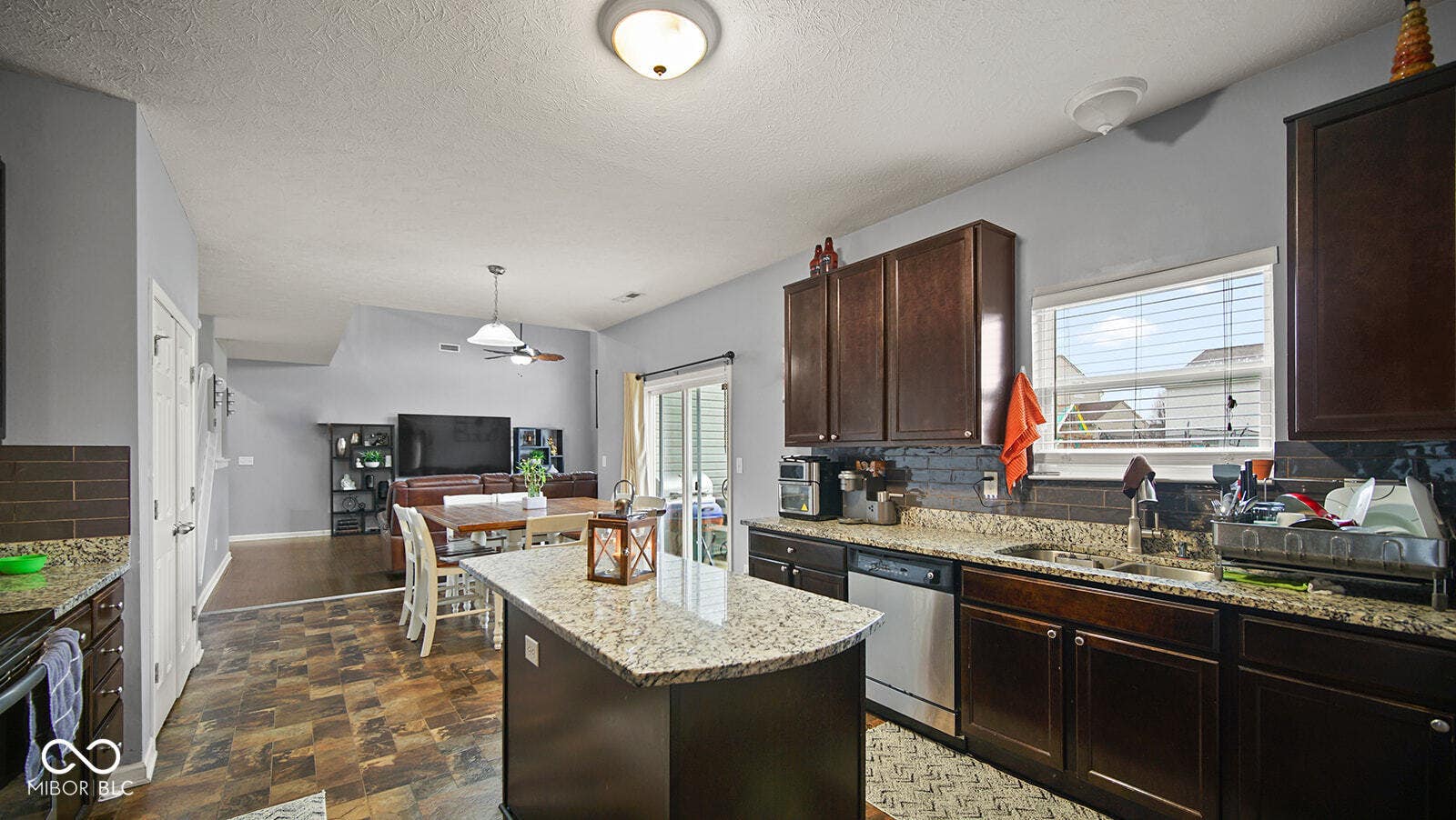 kitchen with dishwasher, a kitchen island, a sink, and backsplash