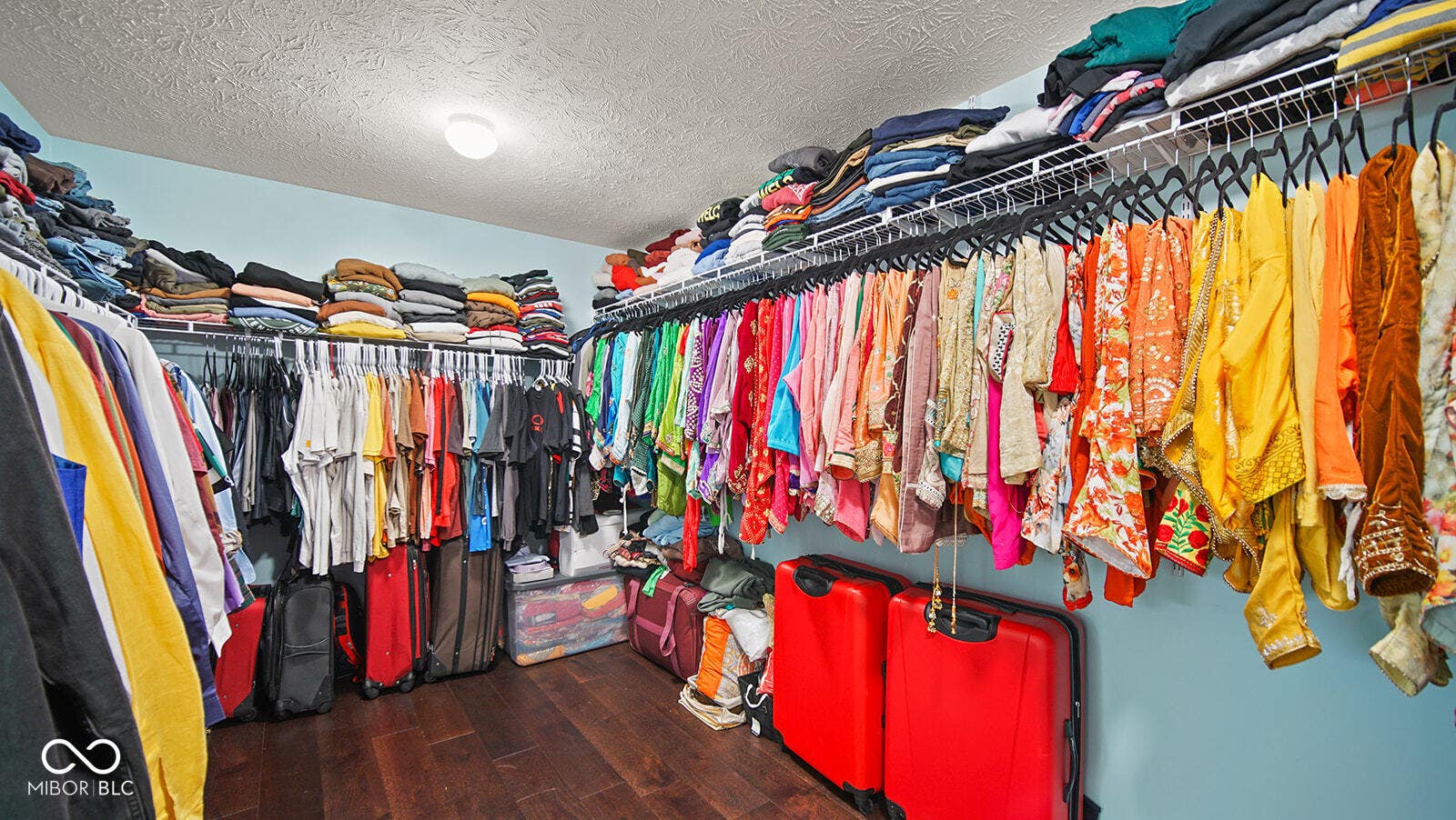 walk in closet with wood finished floors